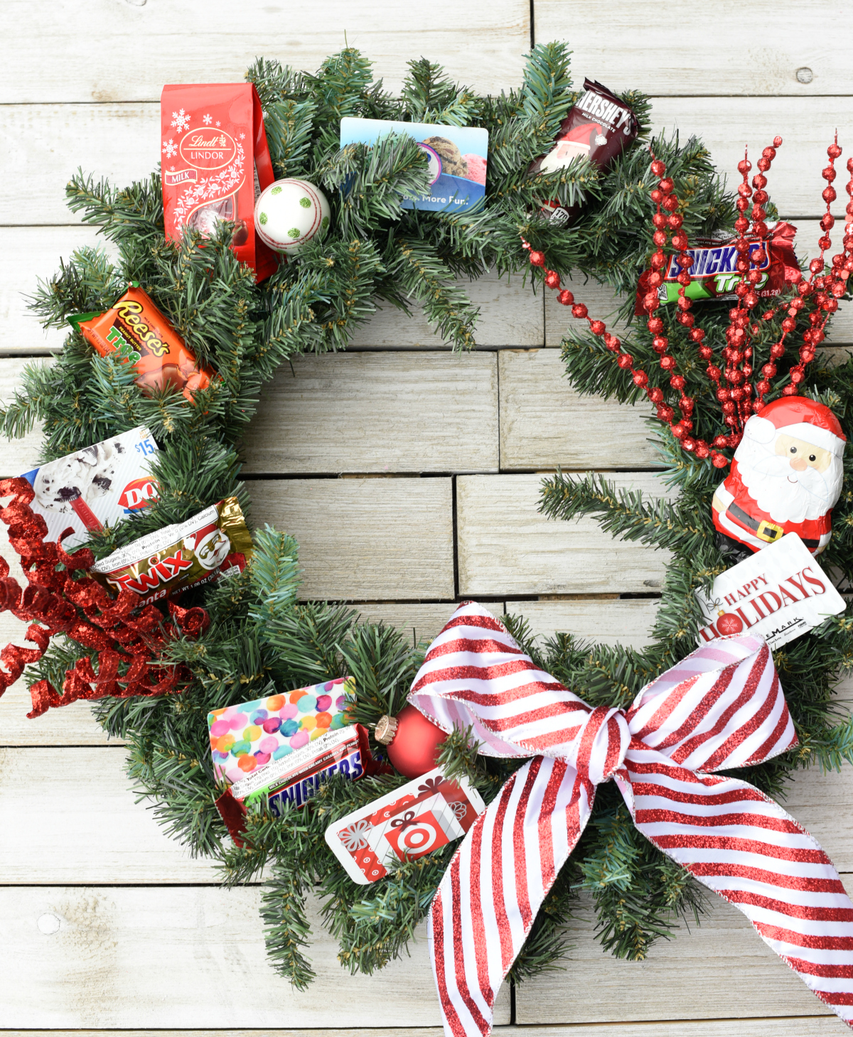 Creative Christmas Gifts-This gift card wreath makes a fun gift to give someone this holiday season! Add gift cards, candy and decorations for a fun, unique and creative Christmas gift idea. #christmasgifts #christmasgiftideas #christmaswreath